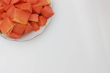 Papaya slices served on a white plate isolated on a white background. concept of healthy food for body digestion.