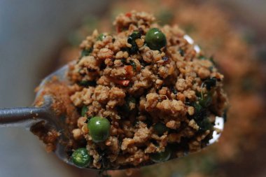 a close up of a side dish with stir-fried leunca and oncom that have been cooked on a frying pan. Indonesian traditional food photo concept.