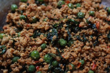 a close up of a side dish with stir-fried leunca and oncom that have been cooked on a frying pan. Indonesian traditional food photo concept.