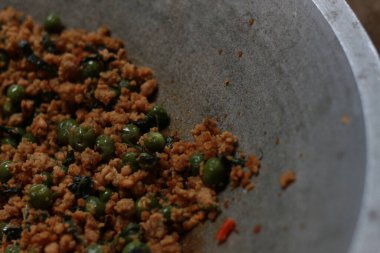 a close up of a side dish with stir-fried leunca and oncom that have been cooked on a frying pan. Indonesian traditional food photo concept.