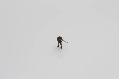 a close up of miniature figure of a hunter with a rifle isolated on white background. Miniature figure photo concept.