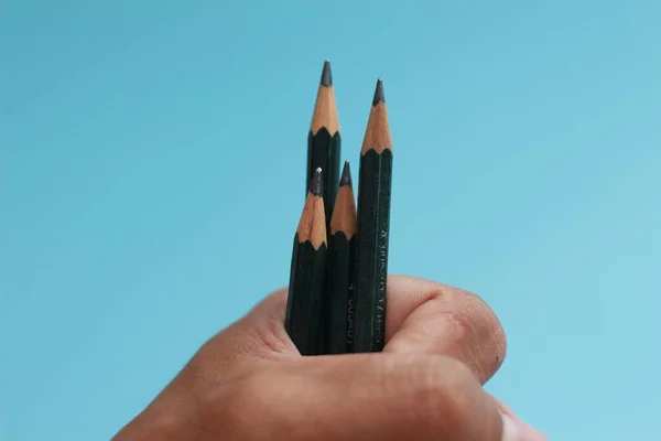 Zbliżenie Kilku Ołówków Ręku Odizolowanych Niebieskim Tle Kreatywna Koncepcja Fotografii — Zdjęcie stockowe