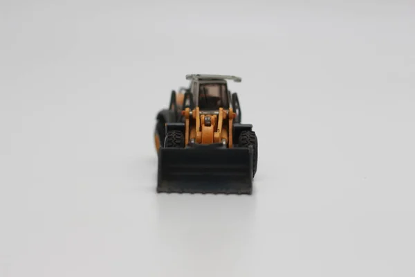 Eine Nahaufnahme Von Miniatur Orangefarbenem Radladerspielzeug Isoliert Auf Weißem Hintergrund — Stockfoto