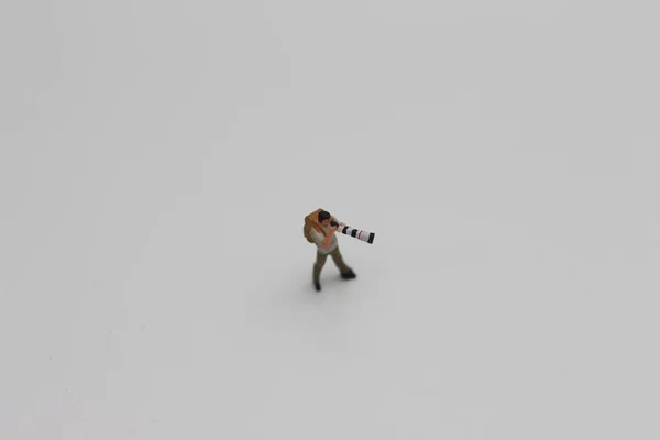 Zbliżenie Miniaturowej Sylwetki Fotografa Aparatem Fotograficznym Teleobiektywem Odizolowanym Białym Tle — Zdjęcie stockowe