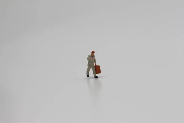 Close Uma Figura Miniatura Funcionário Escritório Carregando Uma Mala Isolada — Fotografia de Stock