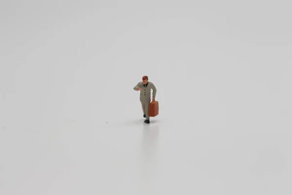 Eine Nahaufnahme Einer Miniaturfigur Eines Büroangestellten Der Einen Koffer Isoliert — Stockfoto