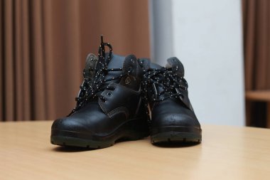 Detailed photo of a pair of safety shoes for work. Work protective equipment concept photo.