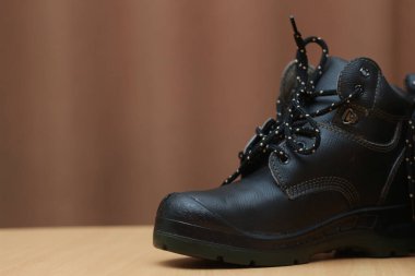 Detailed photo of a pair of safety shoes for work. Work protective equipment concept photo.