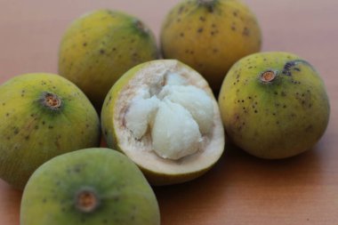 greenish yellow harp fruit isolated on money table has sweet and sour taste. Food concept photo.