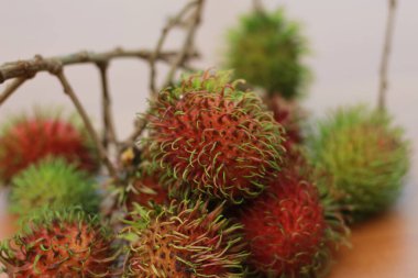 rambutan fruit which is reddish green in color having sweet taste isolated on table. Food concept photo.