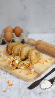 a close up of pastel cake which is a traditional indonesian food. filled with chicken, vegetables, or boiled eggs and served with sauce or chili. Indonesian traditional food photo concept.