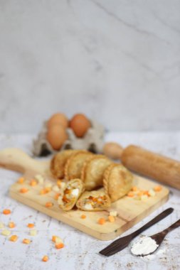 a close up of pastel cake which is a traditional indonesian food. filled with chicken, vegetables, or boiled eggs and served with sauce or chili. Indonesian traditional food photo concept.