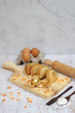 a close up of pastel cake which is a traditional indonesian food. filled with chicken, vegetables, or boiled eggs and served with sauce or chili. Indonesian traditional food photo concept.