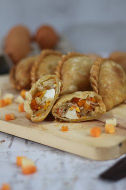 a close up of pastel cake which is a traditional indonesian food. filled with chicken, vegetables, or boiled eggs and served with sauce or chili. Indonesian traditional food photo concept.