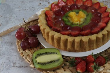 big fruit pie with toppings of strawberries, grapes, kiwi and pineapple. savory, sweet and fresh. Food concept photo.