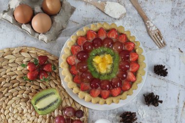 big fruit pie with toppings of strawberries, grapes, kiwi and pineapple. savory, sweet and fresh. Food concept photo.