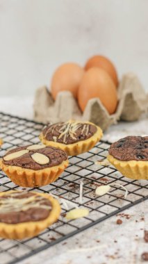 Small chocolate pie with almonds topping served on a cake rack, tastes sweet and savory. Food concept photo.