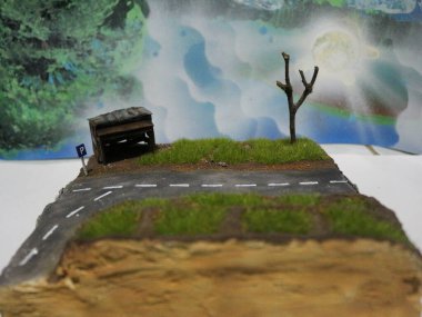 a close up of a diorama of a rice field scene and an old roadside house. miniature diorama photo concept.