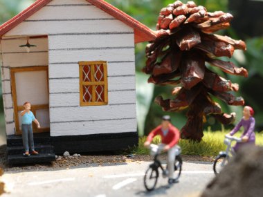 a close up of a miniature figure of a cyclist greeting other people. social photo concept.