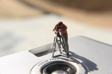miniature figure of a videographer recording on an analog camera.
