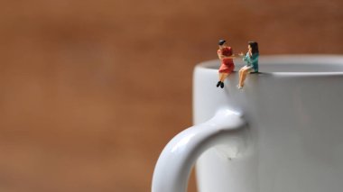 Miniature figures of 2 women talking over glasses. discussion concept.