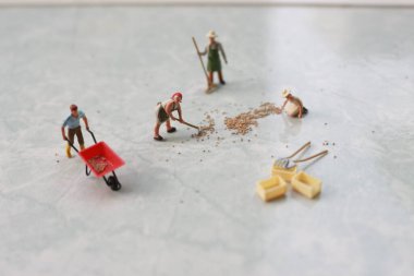 miniature figures of workers working together to move grain.