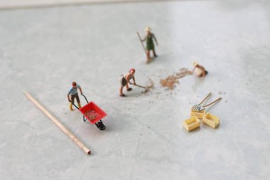miniature figures of workers working together to move grain.