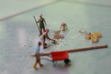 miniature figures of workers working together to move grain.