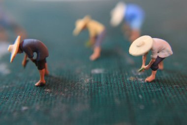 miniature figures of farmers working on a cutting mat. concept of agriculture photo.