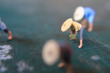 miniature figures of farmers working on a cutting mat. concept of agriculture photo.