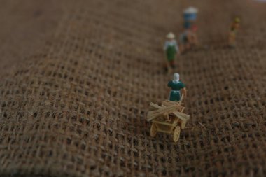 miniature figures of farmers working on gunny sacks. concept of agriculture photo.