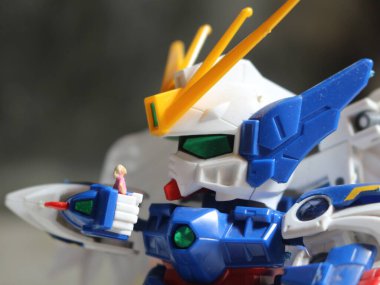 a miniature figure of a girl holding the robot's hand and looking at each other.