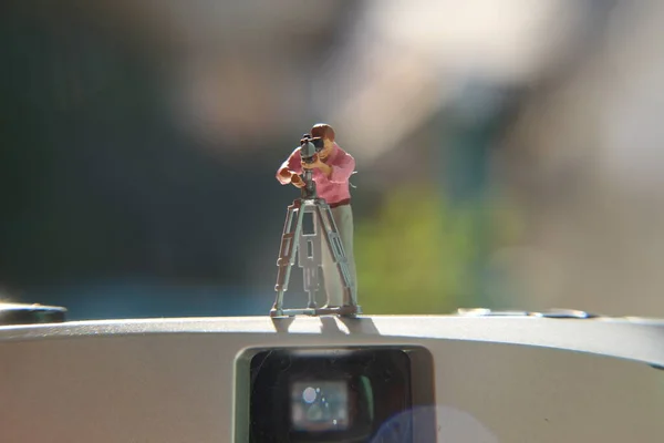 miniature figure of a videographer recording on an analog camera.