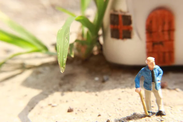 Miniaturowa Postać Dziadka Który Czeka Przed Domem — Zdjęcie stockowe