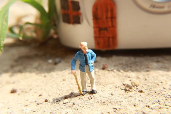 Miniaturowa Postać Dziadka Który Czeka Przed Domem — Zdjęcie stockowe
