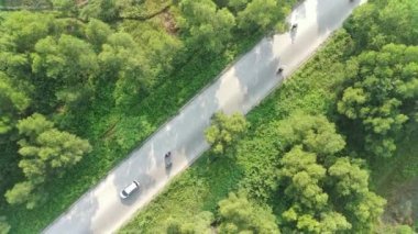 4K footage aerial view of the highway leading to residential areas between green fields.