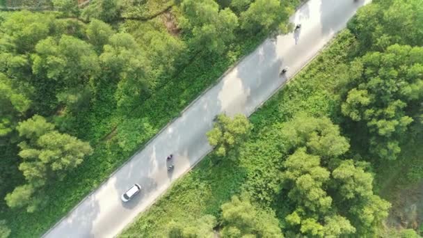 緑のフィールド間の住宅地につながる高速道路の4K空撮 — ストック動画