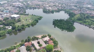 4K footage aerial view of Lake Cirimekar and a cemetery during the day which is in the middle of residential areas.