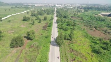 4K görüntüsü Klapanunggal karayolunun ağaçlar ve yeşil açık alan arasındaki görüntüsü.
