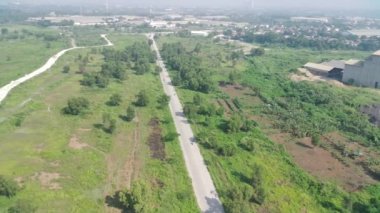 4K görüntüsü Klapanunggal karayolunun ağaçlar ve yeşil açık alan arasındaki görüntüsü.