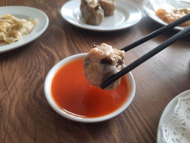 Dim sum, soslu beyaz bir tabakta sıcak servis edilir. izole edilmiş beyaz arkaplan.