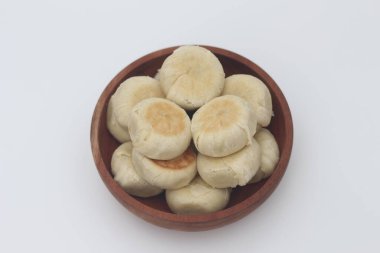 Beyaz arka planda izole edilmiş ahşap bir kasede servis edilen Bakpia 'nın yakın çekimi..