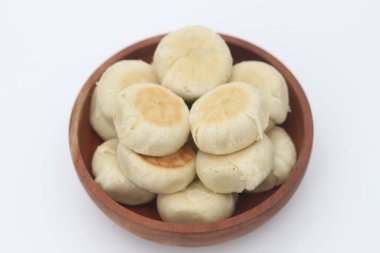 Beyaz arka planda izole edilmiş ahşap bir kasede servis edilen Bakpia 'nın yakın çekimi..