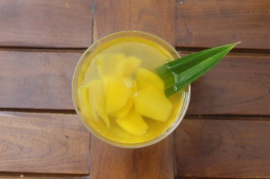 Bir bardak şekerli Carica, ahşap desenli arka planda taze izole edilmiş olarak servis edilir. Endonezya içkileri ve tatlıları. Carica veya Manisan Carica.