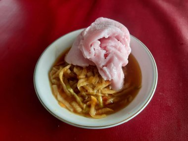 Rujak ya da çilekli dondurmayla kaplı baharatlı meyve salatası. Soğuk tatlı ve ekşi bir tadı var. Yogyakarta 'dan Rujak Eskrim..