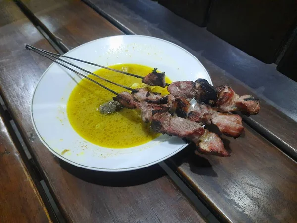 若いヤギ肉から作られたクラタック サタイは 黄色いカレースープで提供されます ジョグジャカルタの人気ストリートフード — ストック写真