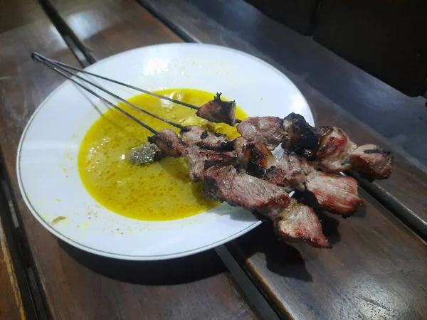 若いヤギ肉から作られたクラタック サタイは 黄色いカレースープで提供されます ジョグジャカルタの人気ストリートフード — ストック写真
