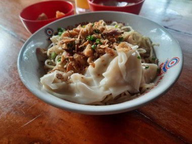 Yogyakarta, Endonezya - Mart 19, 2023. Tavuklu erişte köfte, kızarmış tofu ve soğuk portakal suyu hazır. Düz konsept.