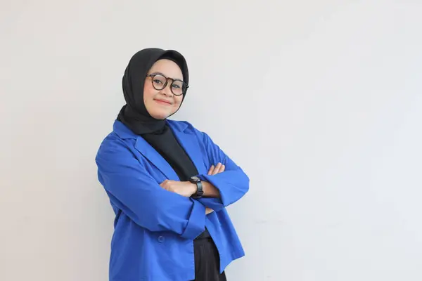 年轻美丽的亚洲穆斯林妇女 戴着眼镜 身穿蓝色夹克 摆出一副专业的姿势 笑着与外界隔绝的白色背景 — 图库照片