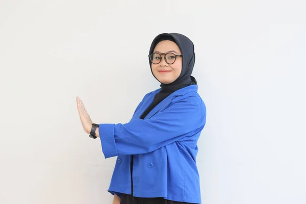 年轻美丽的亚洲穆斯林妇女 戴着眼镜 身穿蓝色夹克 面带微笑 面带孤立的白色背景 表现出停止的姿态 广告概念 — 图库照片